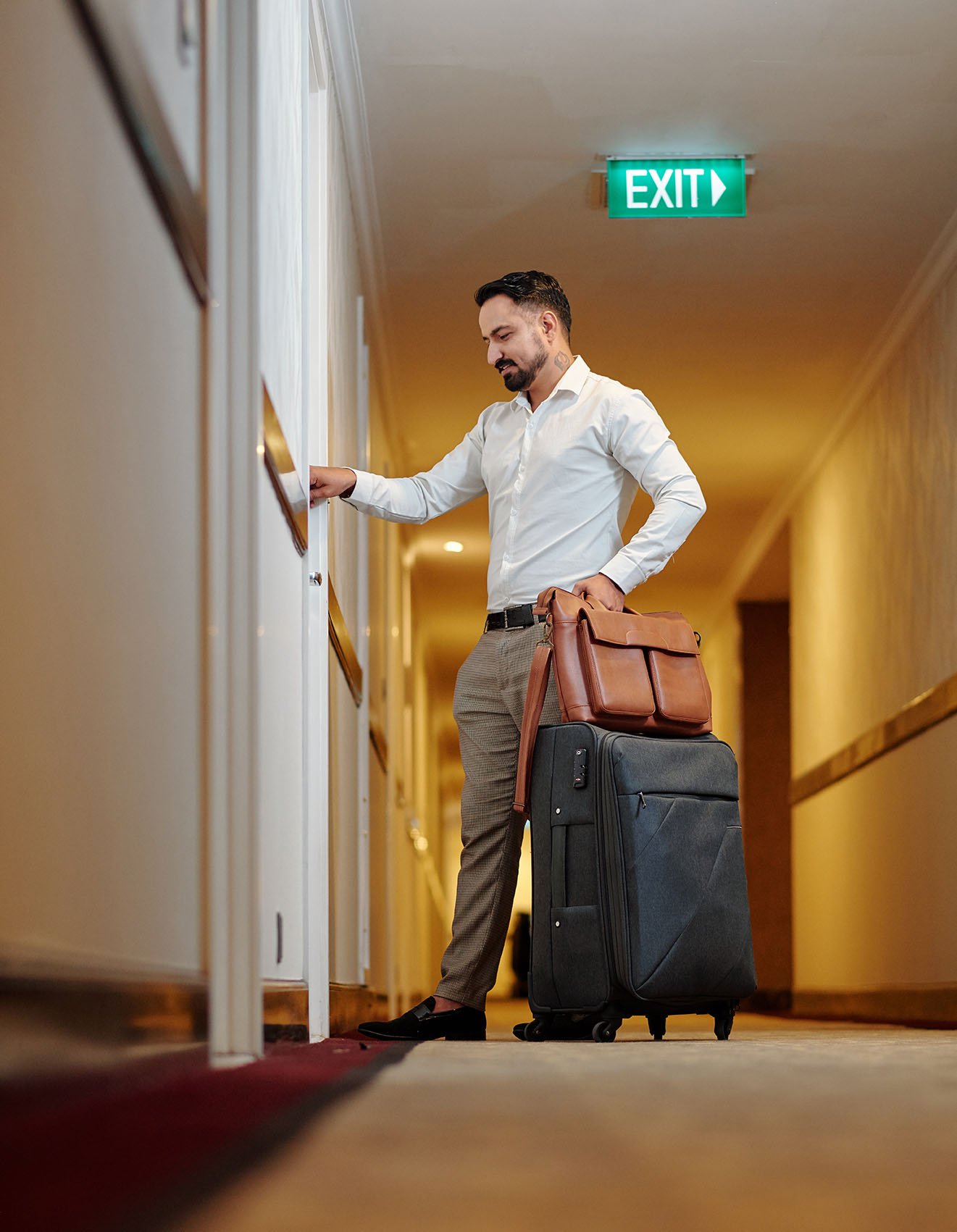A smartly dressed guest arriving at their premium suite at Golden Key Hotel