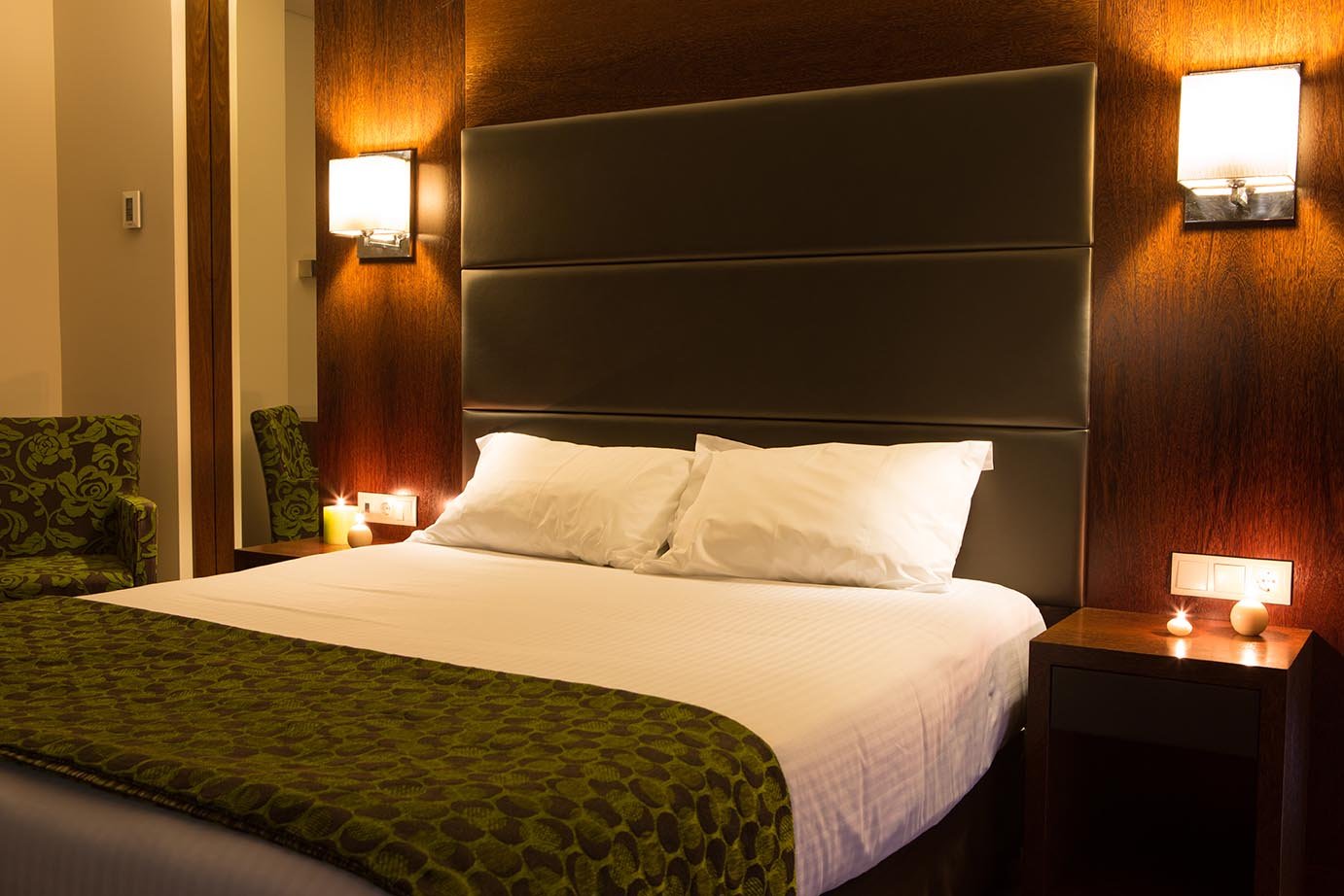 Luxurious Deluxe Suite featuring a plush bed and warm, ambient lighting.